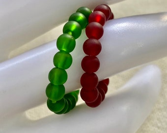 May include: Two stretchy bracelets, one green and one red, made of small round beads.