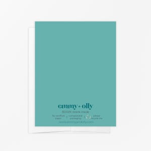 May include: A teal greeting card with a solid color front and text on the back. The back features the text emmy + olly, BD029 | blank inside, fsc certified paper, compostable packaging, please recycle me, and www.emmyandolly.com in dark teal.