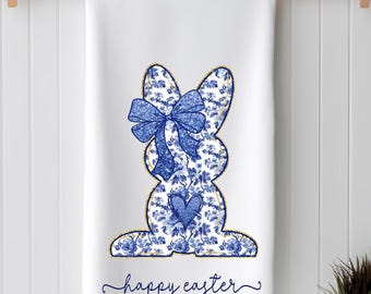 May include: White kitchen towel featuring a blue and white floral patterned bunny with a blue bow and a blue heart. The text "happy easter" is written in cursive below the bunny.