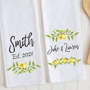 Peut inclure: Deux torchons de cuisine blancs avec des motifs de branches de citron. L'un dit "Smith Est. 2021" et l'autre "Jake & Lauren".