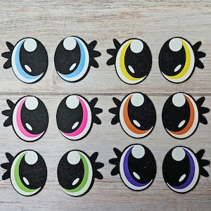Peut inclure: Douze yeux rigolos en feutre avec des pupilles noires et des centres blancs. Chaque œil a une bordure de couleur différente, y compris bleu, jaune, rose, orange, vert et violet.