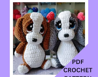 May include: PDF crochet pattern for two amigurumi dogs. One dog is brown and white, the other is gray and white. Both dogs have big eyes and are sitting.