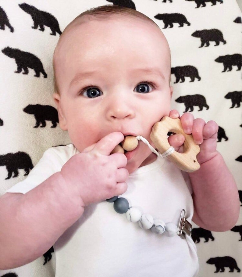 baby chewing on pacifier teething