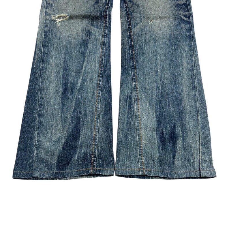 May include: Close-up of light blue denim jeans with a flared leg design. The jeans have distressed details, including a ripped section near the knee. The denim has a faded appearance, with visible stitching and a classic five-pocket style.