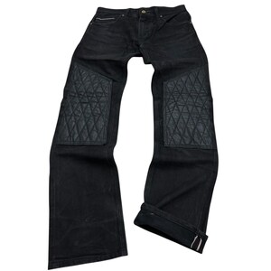 Peut inclure: Jean noir avec des patchs matelassés aux genoux. Le jean a une conception classique à cinq poches et une coupe droite. Les poignets sont retroussés, révélant un accent rouge. Un ajout élégant et durable à toute garde-robe.