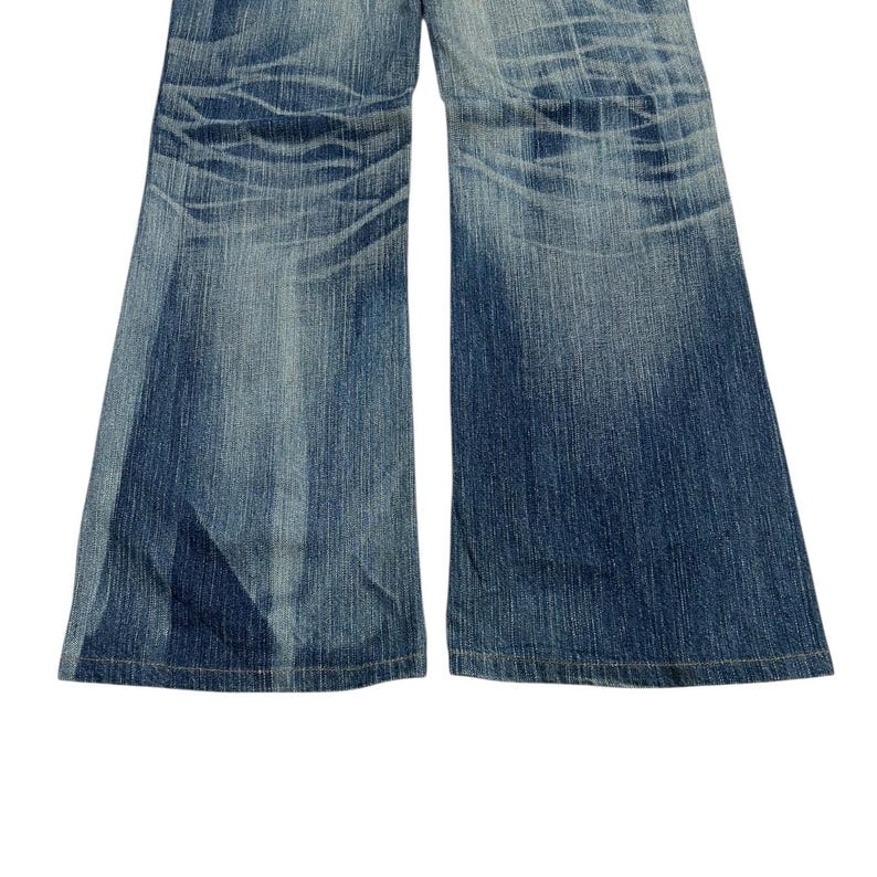 May include: A pair of blue denim jeans with a wide leg cut. The jeans have a faded wash effect and visible wear marks. The fabric is a medium weight denim, and the jeans appear pre-worn.