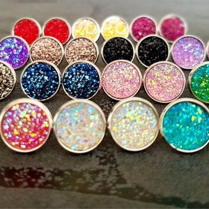 Pode incluir: Conjunto de 18 pares de brincos de pressão redondos com glitter em várias cores, incluindo rosa, azul, verde e prata.
