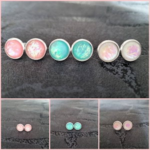 Op de afbeelding: Zes paar iriserende oorbel studs in roze, turquoise en wit. De oorbellen zijn gezet in zilver.