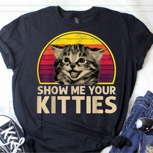 Könnte beinhalten: Schwarzes T-Shirt mit einem Vintage-Grafik eines Katers mit dem Text "Show Me Your Kitties".
