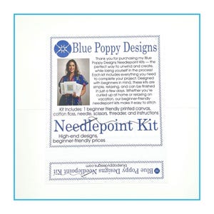 May include: A white informational card for Blue Poppy Designs Needlepoint Kit. The text details kit contents including a printed canvas, cotton floss, needle, scissors, threader, and instructions. A small photograph shows a person holding a kit.
