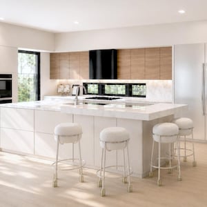 May include: A modern kitchen with white cabinetry, a large island with seating, and a stainless steel range hood. The island features white upholstered stools. The kitchen has a built-in oven and a wine refrigerator.