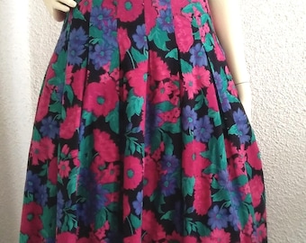 May include: A black pleated skirt with a floral print featuring pink, blue and green flowers.