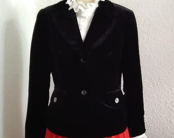May include: A black velvet blazer with a white lace collar and a red pleated skirt.