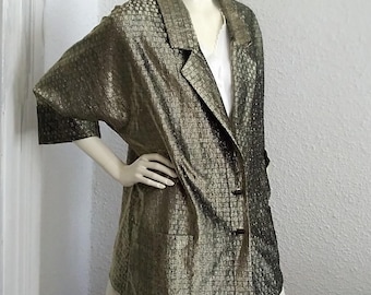 May include: A gold metallic blazer with a long, loose fit and a collar. The blazer has a checkered pattern and three buttons down the front.