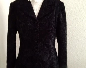 May include: A black velvet blazer with a floral pattern. The blazer has a single button closure and long sleeves.