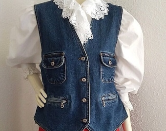 Op de afbeelding: Een denim vest met een witte kanten kraag, gedragen over een wit blouse en een rode geplooide rok.