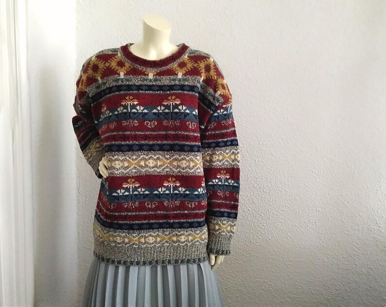 May include: A colorful striped sweater with a geometric pattern in shades of red, blue, yellow, and white.