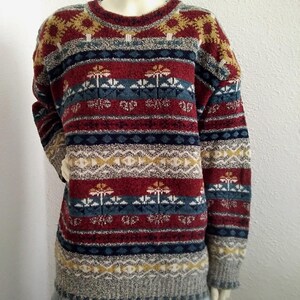 May include: A multi-colored striped sweater with a geometric pattern. The sweater is made of a soft, fuzzy material and has a crew neck.