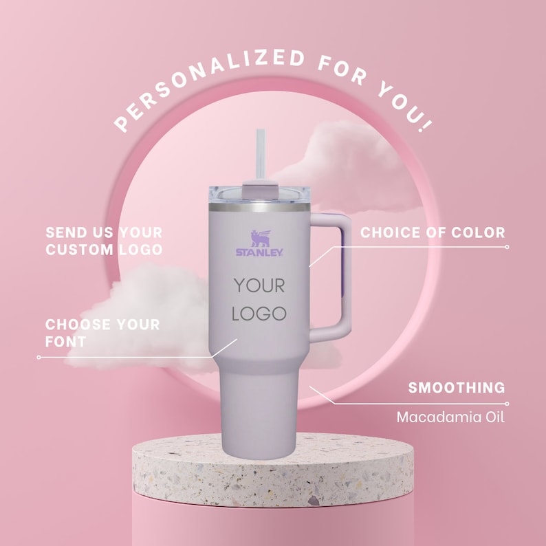 May include: A personalized stainless steel travel mug with a purple lid and handle. The mug has a white background with the text "STANLEY" and "YOUR LOGO" in black. The mug is sitting on a pink and white surface. The text "PERSONALIZED FOR YOU!" is in a circle above the mug. The text "SEND US YOUR CUSTOM LOGO" is on the left side of the mug. The text "CHOOSE YOUR FONT" is below the mug. The text "CHOICE OF COLOR" is on the right side of the mug. The text "SMOOTHING Macadamia Oil" is below the mug.