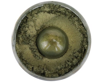Könnte beinhalten: Ein kleines Glas mit grünem Glimmerpulver und einer kleinen Probe des Pulvers in der Mitte.