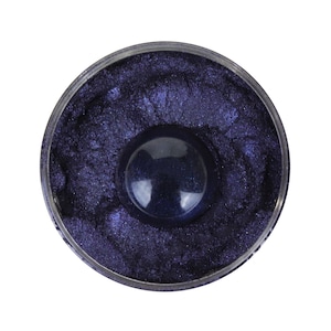 May include: A close-up view of a small container filled with a deep purple iridescent mica powder.