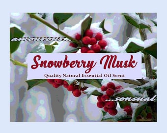 Puede incluir: Primer plano de un arbusto de acebo con bayas rojas cubiertas de nieve. El texto "Snowberry Musk" está escrito en una fuente decorativa con las palabras "Quality Natural Essential Oil Scent" debajo. Las palabras "...amorous..." y "...sensual..." están escritas en una fuente más pequeña a cada lado del arbusto.