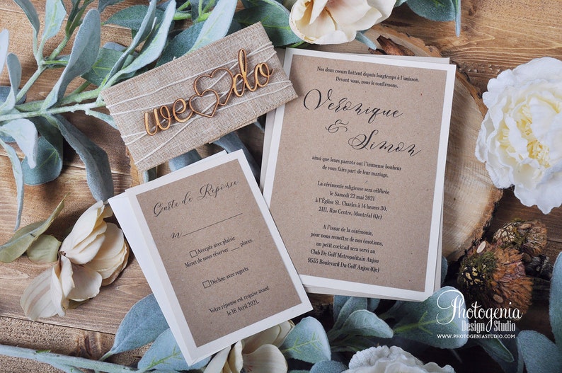 K&ouml;nnte beinhalten: Eine rustikale Hochzeitseinladungssuite mit einem Hintergrund aus Kraftpapier. Die Einladung zeigt die Namen des Paares, "Veronique & Simon", in eleganter Kalligraphie. Die RSVP-Karte enth&auml;lt ein Kontrollk&auml;stchen zum Akzeptieren oder Ablehnen der Einladung. Die Einladung ist mit einem h&ouml;lzernen "we do"-Schild und Gr&uuml;npflanzen verziert.