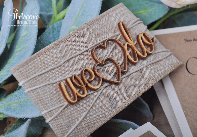 K&ouml;nnte beinhalten: Nahaufnahme einer rustikalen Burlap-Hochzeitsgeschenkbox mit dem Wort "Hochzeit" in Kursivschrift auf einem Holzhertz. Die Box ist mit Schnur gebunden und hat ein nat&uuml;rliches, erdiges Gef&uuml;hl.