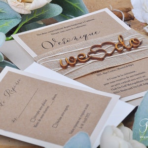 K&ouml;nnte beinhalten: Eine rustikale Hochzeitseinladung mit braunem Papierhintergrund und einem Juteband. Die Einladung zeigt ein Holzschild mit der Aufschrift "We Do" und einem Herz in der Mitte. Der Text auf der Einladung lautet "Veronique" und "2111, Rue Centre, Montreal (H1Y)".