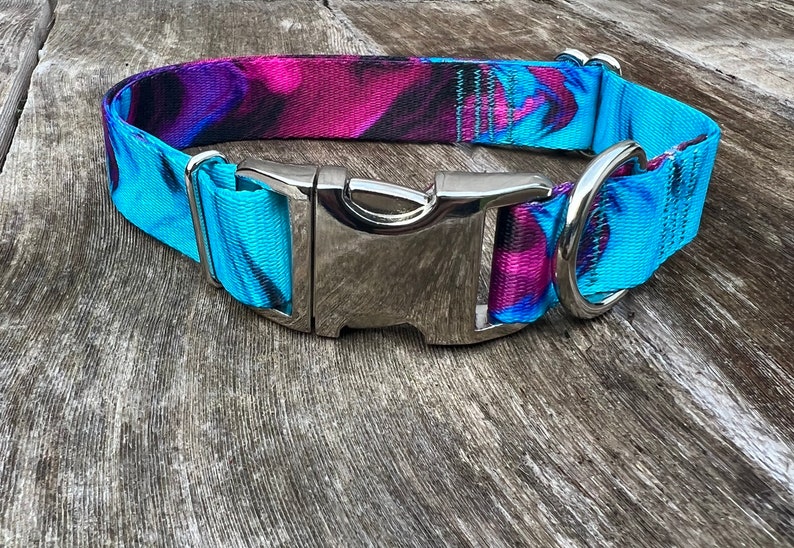 May include: A blue and purple patterned dog collar with a silver buckle and D-ring.