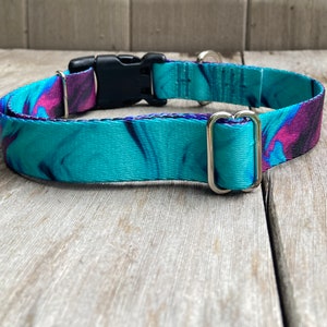 May include: A turquoise and purple patterned dog collar with a black plastic buckle and silver D-rings.