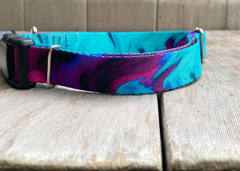 May include: A turquoise, purple, and black marbled dog collar with a black buckle and silver D-ring.