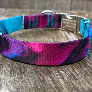 May include: A purple, blue, and black patterned dog collar with a silver buckle.
