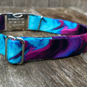 May include: A blue and purple patterned dog collar with a silver buckle and D-ring.