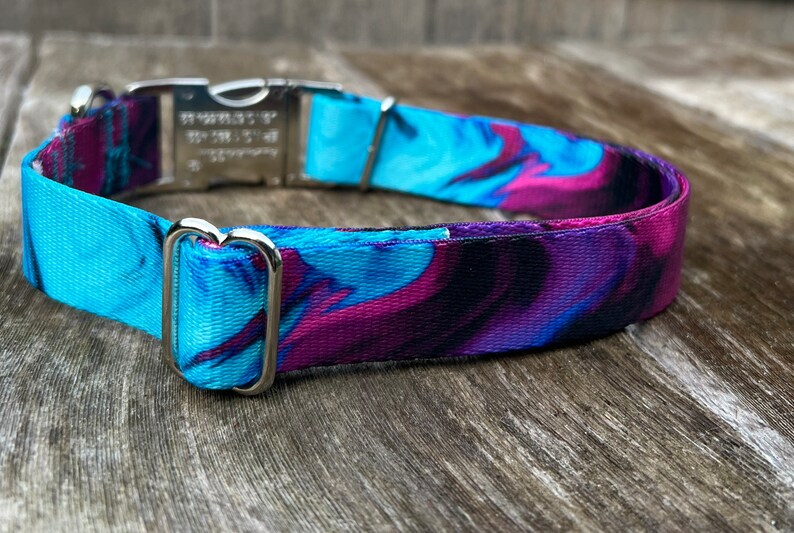 May include: A blue and purple patterned dog collar with a silver buckle and D-ring.