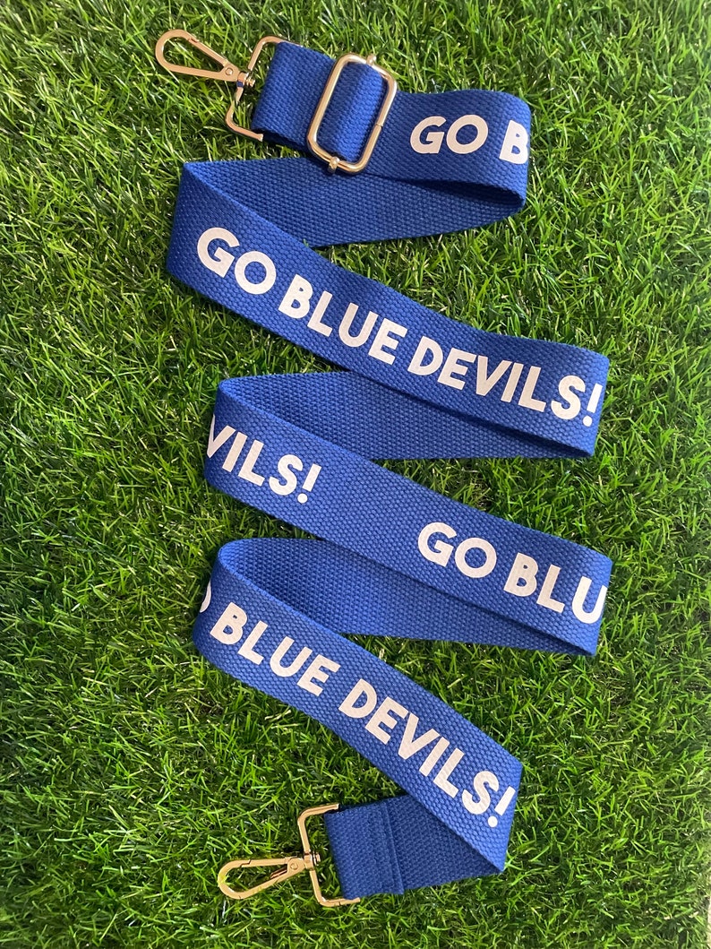 Op de afbeelding: Blauw-witte verstelbare band met de tekst "GO BLUE DEVILS!" aan beide kanten.