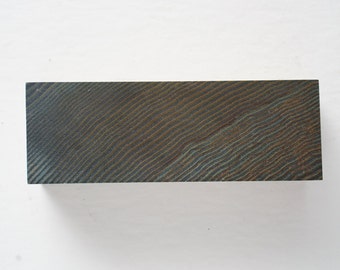 May include: A dark grey rectangular block of wood with a wavy grain pattern.