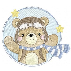 May include: A brown bear wearing a blue and white striped scarf and aviator goggles, with yellow stars, is inside a blue circle with white stripes. The text "5 SIZES" is below the circle.