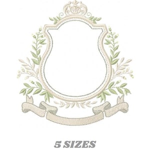 May include: An embroidered design featuring a shield-shaped frame with a crown, surrounded by leaves and a banner. The design is in shades of beige and green, with the text "5 SIZES" below.