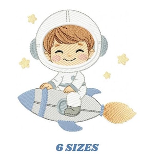 Op de afbeelding: Geborduurd ontwerp van een lachende astronaut in een wit ruimtepak en helm, rijdend op een lichtblauwe en grijze raket. Gele sterren omringen de astronaut. De tekst "6 SIZES" staat eronder.