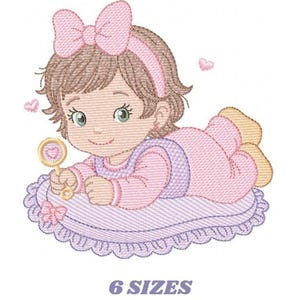 May include: An embroidered illustration of a baby girl in pink pajamas, a matching bow, and a headband. She is lying on a purple pillow and holding a rattle. The image includes the text "6 SIZES".