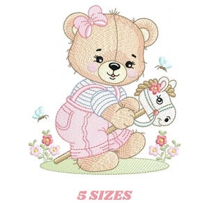 May include: An embroidered design of a teddy bear wearing pink overalls and a striped shirt, holding a stick horse. The bear has a pink bow and is surrounded by flowers and butterflies. The text "5 SIZES" is at the bottom.