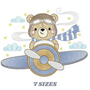 May include: Embroidered design of a brown bear wearing aviator goggles and a blue and white striped scarf, flying a blue airplane with a yellow propeller. The design is surrounded by white clouds and yellow stars.