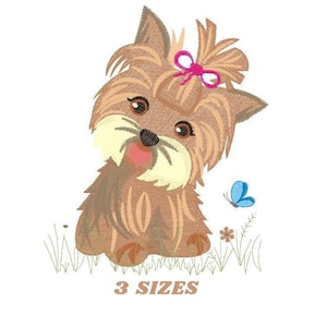 Peut inclure: Broderie représentant un chiot Yorkshire Terrier brun et blanc avec un nœud rose, assis dans un champ d'herbe verte avec un papillon bleu.