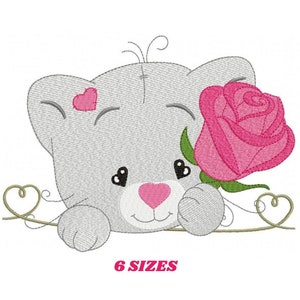Op de afbeelding: Borduurontwerp van een grijze kat met een roze roos en twee harten. De kat kijkt naar de roos en heeft een roze neus. Het ontwerp is perfect voor borduurprojecten.