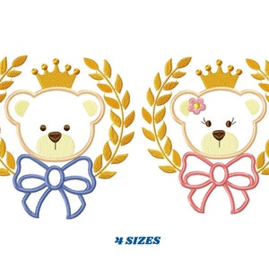 Pode incluir: Dois desenhos bordados de ursos de peluche com coroas e laços. O urso menino tem um laço azul e o urso menina tem um laço rosa. Ambos os ursos estão rodeados por coroas de louro douradas.