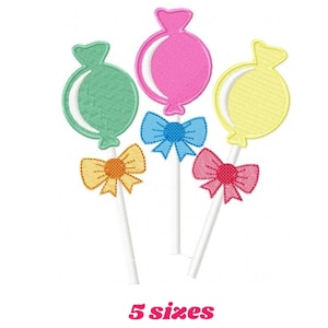 May include: Three colorful candy lollipops with bows. The lollipops are green, pink, and yellow. The bows are blue, orange, and pink.