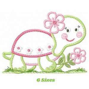 以下が含まれることがあります： 笑顔の顔をした漫画の亀のデザインで、花の冠をかぶり、花を持っています。 亀は緑と白で、ピンクのアクセントがあります。 テキスト「6 Sizes」が下にあります。