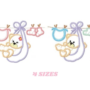 Puede incluir: Dos diseños de bordado que presentan un osito de peluche en una bandolera para bebé con un babero y botines colgados de una cuerda para tender la ropa. El diseño de la izquierda es rosa y morado, y el diseño de la derecha es azul y verde. El texto "24 SIZES" está debajo de los diseños.