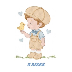 Puede incluir: Diseño bordado de un niño pequeño con gorra beige, peto y botas, sosteniendo un pollito amarillo. Corazones azul claro flotan alrededor del niño. El texto "5 TAMAÑOS" está debajo.